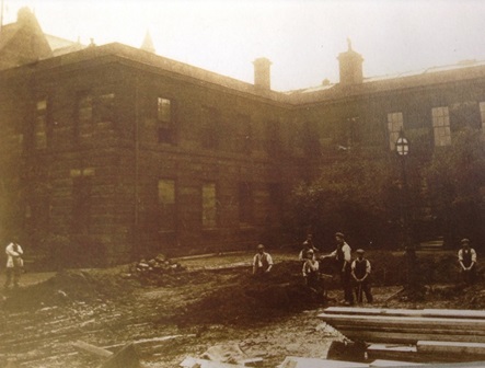 The only surviving photograph of the asylum around 1914 with demolition crew standing in the foreground.