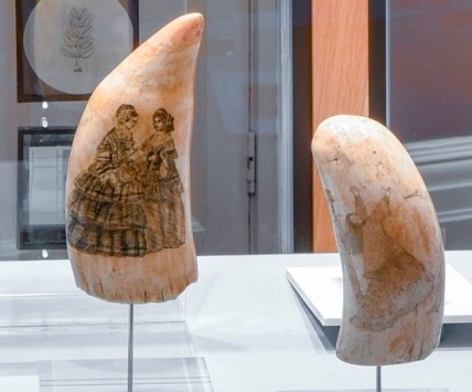 Engraved whalebone depicting two ladies with a book. Engraved walrus tusk depicting a dual, the female with her arms aloft.