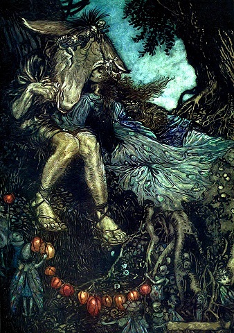 Queen Titania, with long brown hair and a crown, wearing a blue flowing dress cuddles up to a man named Bottom. He has a donkey’s head and is bare legged. Small, fairy-like creatures are gathered round the bottom of the image. 