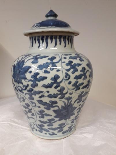 A baluster-shaped jar with a lid. The body has a blue design on white ground featuring a scrolling floral design. The flowers are probably peonies.