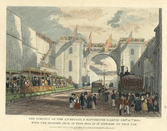 A busy scene. To the left are ornate coaches packed with people inside. The men wear black coats and top hats and the women are in colourful Victorian dress. In the foreground are more figures including uniformed soldiers with red jackets and tall, bearskinned hats. In the background is a large archway with towers either side. People are stood all along the parapet of this structure and flags hand