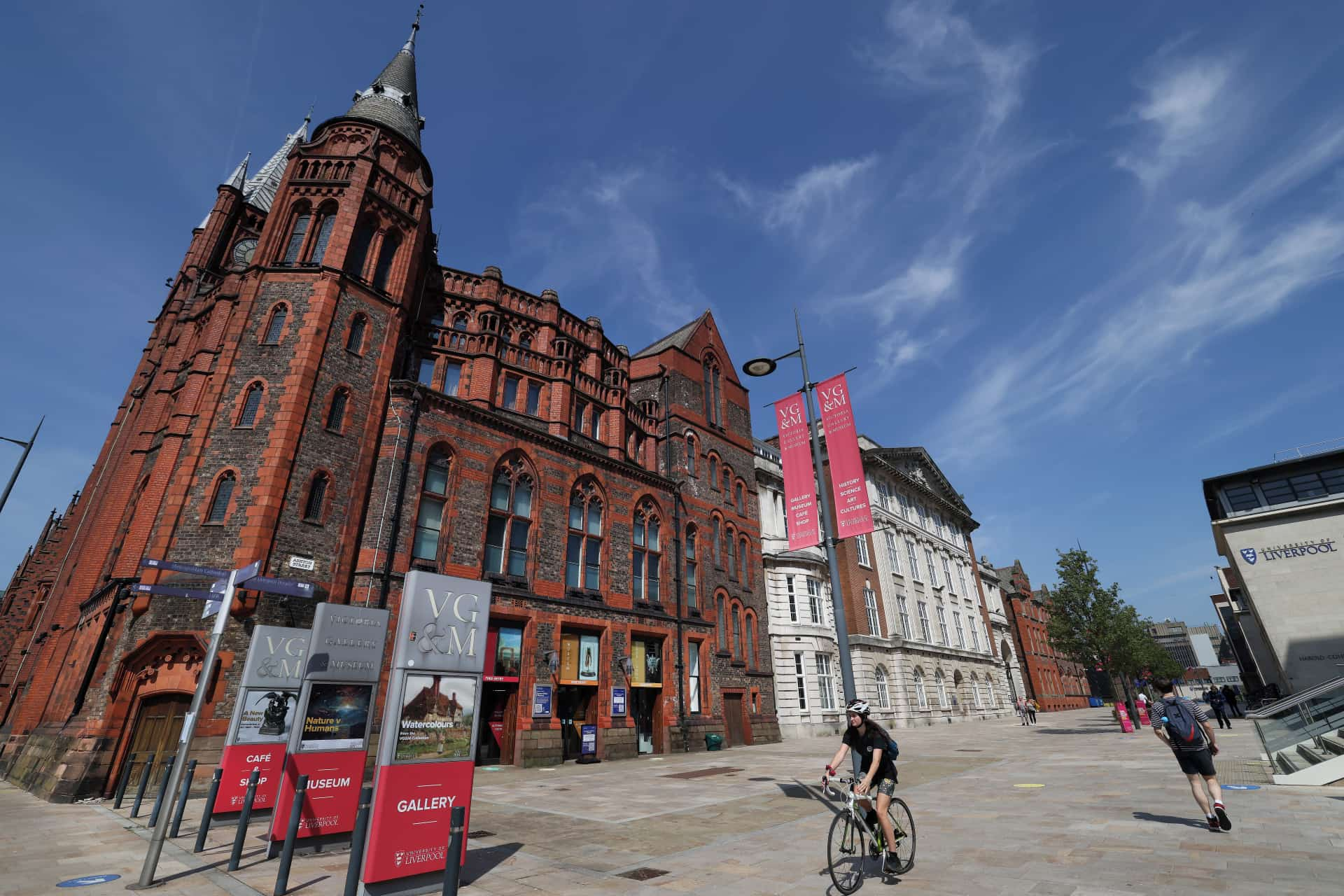 The exterior of the Victoria Gallery & Museum  on a sunny day. Someone is riding past on a bicycle.