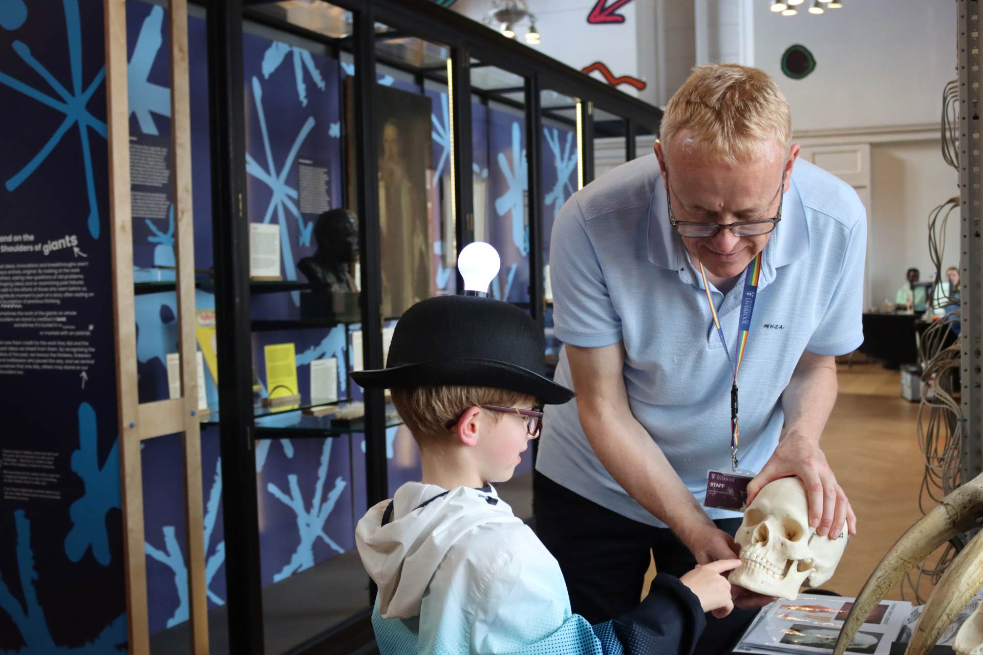 An academic shows a young boy a replica of a skull